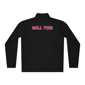 May include: Black long-sleeve pullover with a mock neck collar. The text "ROLL TIDE" is printed across the back in red block letters. The pullover has a zipper that goes up to the collar.