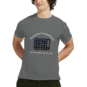 May include: A heather grey t-shirt with a white graphic of a phone keypad with the alphabet printed on it. The text "Presume Competence" is above the keypad and the text "Let me spell it out for you!" is below the keypad.