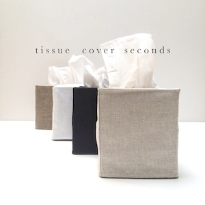 May include: Four rectangular tissue box covers in beige, white, and black fabric, each holding white tissues. The text "tissue cover seconds" is printed above the covers. The covers are arranged in a row, showcasing their textured material.