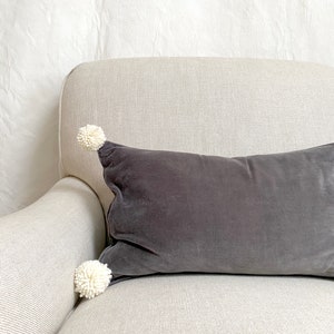 Almohada de terciopelo con pompones - gris
