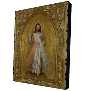 May include: A rectangular wall plaque featuring a central depiction of Jesus Christ with a golden halo, wearing a white robe with red and blue rays emanating from the chest, set within an ornate gold-toned frame with intricate floral carvings.