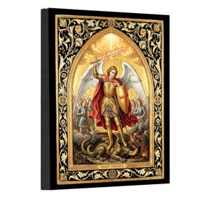 Op de afbeelding: Een rechthoekige wandkunstprint met de heilige Michaël in een gouden harnas met witte vleugels, die een vlammend zwaard en schild vasthoudt terwijl hij boven een draak staat. Het tafereel is omlijst door een zwarte en gouden rand met de tekst SAINT MICHAEL.