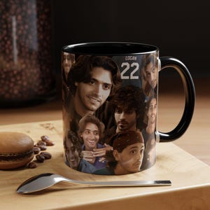 Puede incluir: Una taza de cerámica negra con un collage de fotos de una persona de cabello oscuro en varias expresiones y poses. El texto LOGAN 22 está impreso en blanco cerca de la parte superior. La taza tiene un interior y un asa de color negro.