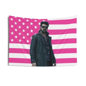 May include: A rectangular wall hanging with a pink and white American flag design. A person wearing sunglasses and a black leather coat stands in front of the flag. The tapestry is made of fabric and is likely for interior decoration.