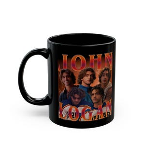 Puede incluir: Taza de cerámica negra con un diseño de estilo vintage. El diseño presenta el nombre "JOHN LOGAN" en letras naranjas y un collage de cinco hombres. La taza tiene un asa curvada.