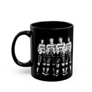 Puede incluir: Taza de cerámica negra con una imagen en blanco y negro de cuatro jugadores de hockey. Los jugadores visten uniformes de hockey con la palabra "Briar" y los números 46, 66, 44 y 22. La taza tiene un asa curva.