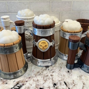 May include: A collection of decorative beer mugs with faux foam tops. The mugs are made of wood-like material with metal accents. Some mugs feature a skull emblem. The mugs are designed to resemble traditional beer steins.