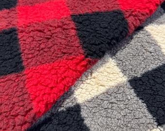 May include: Two pieces of fabric with a checkered pattern. One piece is red and black, the other is black, white, and gray. Both fabrics have a soft, fuzzy texture.