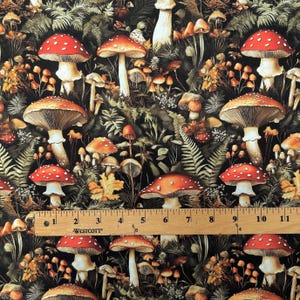 Fabric printed with a dark botanical mushroom pattern, laid flat with a wooden Westcott ruler placed across the middle showing scale up to eleven inches.
