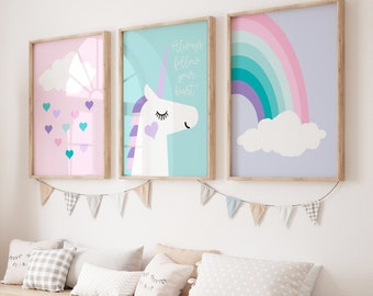 May include: Three framed prints with a pastel color scheme. The left print features a pink background with a white cloud and a rainbow of hearts. The middle print features a light blue background with a white unicorn with purple and pink accents and the text "Always follow your heart". The right print features a light purple background with a rainbow and a white cloud.