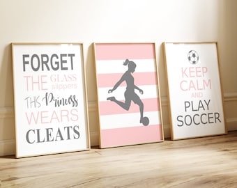 Könnte beinhalten: Drei gerahmte Drucke mit motivierenden Zitaten über Fußball. Der erste Druck ist rosa und weiß gestreift mit einer Silhouette eines Mädchens, das Fußball spielt. Der zweite Druck ist weiß mit dem Text "Vergiss die Glasslipper, diese Prinzessin trägt Stollen". Der dritte Druck ist weiß mit dem Text "Ruhe bewahren und Fußball spielen".