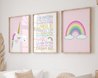 Puede incluir: Tres impresiones enmarcadas en rosa con texto inspirador para niños. La impresión de la izquierda presenta un unicornio blanco con un corazón rosa y una crin arcoíris. La impresión del medio tiene el texto "Eres un unicornio, gira y baila, alcanza las estrellas, sonríe, vístete, ten fiestas de pijamas, pinta arcoíris, canta, ríe a menudo, cree en los cuentos de hadas, sueña en grande". La impresión de la derecha presenta un arcoíris con nubes sobre un fondo rosa.