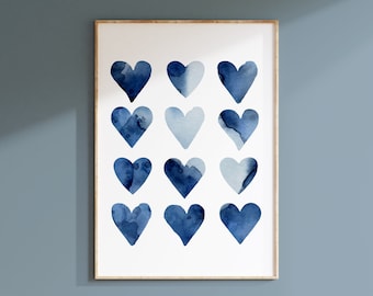 Könnte beinhalten: Ein rechteckiger Wandkunstdruck in einem hellen Holzrahmen mit einem Raster aus zwölf Aquarellherzen in verschiedenen Blautönen. Die Herzen sind in vier Reihen zu je drei angeordnet und zeigen unterschiedliche Texturen und Verläufe in Indigo.