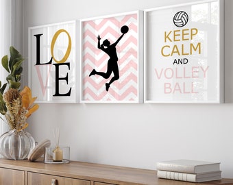 May include: Three white framed prints with black text and images. The left print says "LOVE" in black letters. The middle print has a pink and white chevron pattern with a silhouette of a volleyball player spiking the ball. The right print says "Keep Calm and Volley Ball" with a gold volleyball graphic.