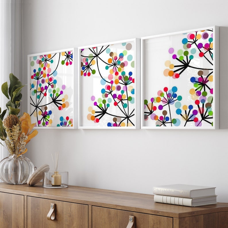 Puede incluir: Tres impresiones enmarcadas con dise&ntilde;os florales abstractos. Cada impresi&oacute;n presenta un fondo blanco con tallos negros y c&iacute;rculos coloridos.