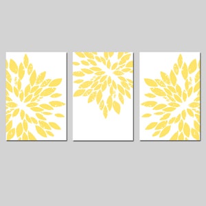 May include: Set of three yellow floral prints with a distressed look. Each print features a circular design of yellow petals on a white background.