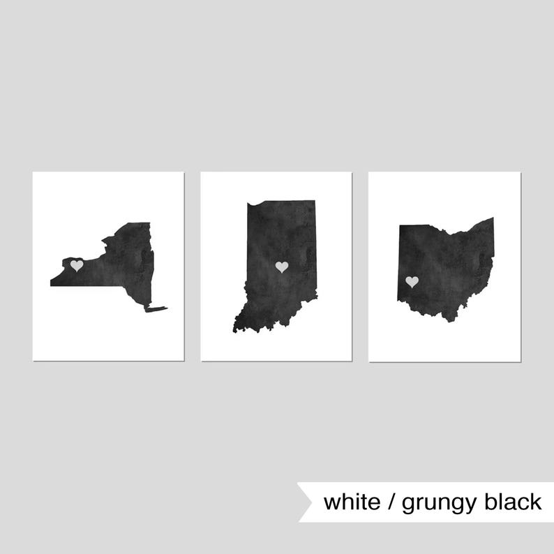May include: Three black and white state silhouette prints with a white heart in the center of each state. The states are New York, Indiana, and Ohio. The prints are on a white background. The text "white / grungy black" is below the prints.