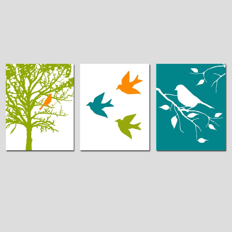 K&ouml;nnte beinhalten: Set aus drei Wandbildern mit einem gr&uuml;nen Baum mit einem orangefarbenen Vogel, einem wei&szlig;en Hintergrund mit drei V&ouml;geln in Blau, Gr&uuml;n und Orange und einem blaugr&uuml;nen Hintergrund mit einem wei&szlig;en Zweig und einem wei&szlig;en Vogel.
