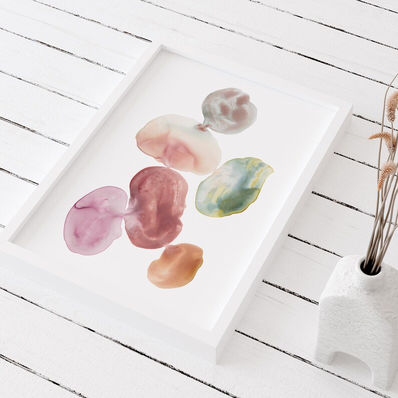 Pode incluir: Pintura abstrata em aquarela com seis formas de diferentes cores em tons de rosa, vermelho, verde, marrom e bege. As formas est&atilde;o dispostas em um grupo e parecem flutuar sobre um fundo branco.