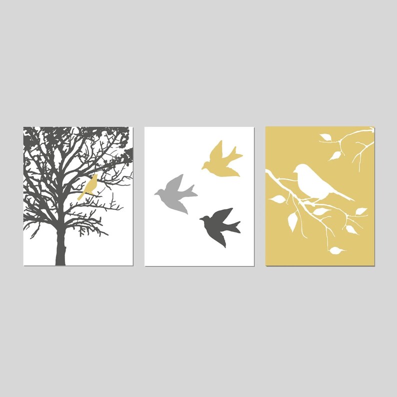 Puede incluir: Conjunto de tres impresiones de arte de pared minimalistas con siluetas de p&aacute;jaros y ramas. La primera impresi&oacute;n muestra un p&aacute;jaro amarillo posado en una rama de &aacute;rbol desnuda. La segunda impresi&oacute;n muestra tres p&aacute;jaros en vuelo, uno gris y dos negros. La tercera impresi&oacute;n muestra un p&aacute;jaro blanco posado en una rama con hojas blancas sobre un fondo amarillo.