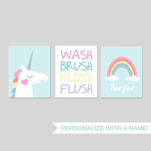 May include: Three bathroom wall art prints with a unicorn, rainbow, and the words "Wash, Brush, Floss, Flush". The rainbow print is personalized with the name "Harper".