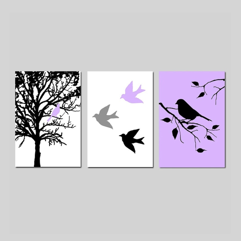 Puede incluir: Un conjunto de tres impresiones de arte de pared con siluetas negras de p&aacute;jaros y ramas sobre un fondo blanco, gris y lavanda.