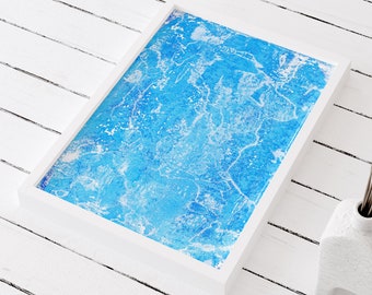 May include: A white frame with a blue abstract painting inside. The painting has a textured look and is reminiscent of water.