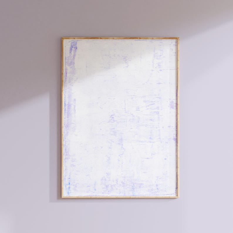 May include: A framed abstract painting with a white background and subtle purple brushstrokes. The frame is a light wood color.