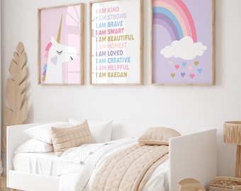 May include: Three framed prints with a unicorn, a rainbow, and a list of positive affirmations. The unicorn is white with a pink mane and tail. The rainbow is multi-colored and has a cloud with hearts underneath. The affirmations are written in colorful text and include phrases like "I am kind", "I am strong", and "I am creative".