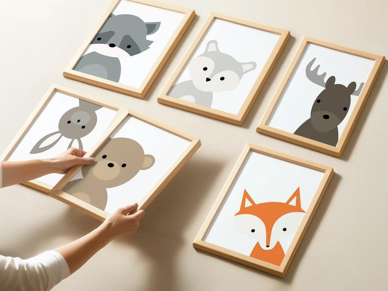 May include: Six framed prints with different animal illustrations. The prints are in a light wood frame and feature a fox, a raccoon, a bunny, a bear, a wolf, and a moose. The prints are all in a minimalist style with simple lines and colors.