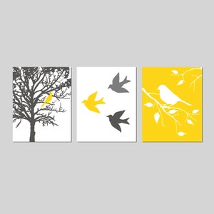 Puede incluir: Un conjunto de tres impresiones de arte de pared con un esquema de color amarillo y gris. La primera impresi&oacute;n muestra una silueta de un &aacute;rbol con un p&aacute;jaro amarillo posado en una rama. La segunda impresi&oacute;n muestra tres p&aacute;jaros en vuelo, dos grises y uno amarillo. La tercera impresi&oacute;n muestra un fondo amarillo con una rama blanca y un p&aacute;jaro blanco posado en ella.