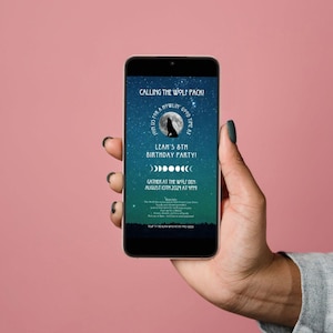 Puede incluir: Un teléfono inteligente que muestra una invitación azul y verde con un lobo aullando a la luna. La invitación dice "Calling the Wolf Pack! Lean's 8th Birthday Party! Gather at the Wilden August 15th, 2021 at 7PM."