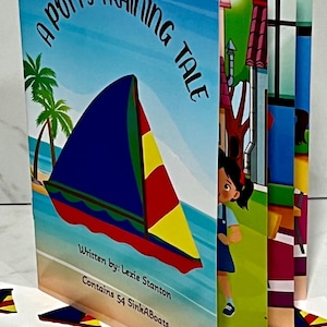 K&ouml;nnte beinhalten: Ein Kinderbuch mit dem Titel "The Adventures of SinkABoat: A Potty Training Tale". Das Cover zeigt ein Segelboot mit blauem Segel, roten und gelben Akzenten und Palmen. Das Buch enth&auml;lt 54 SinkABoats.