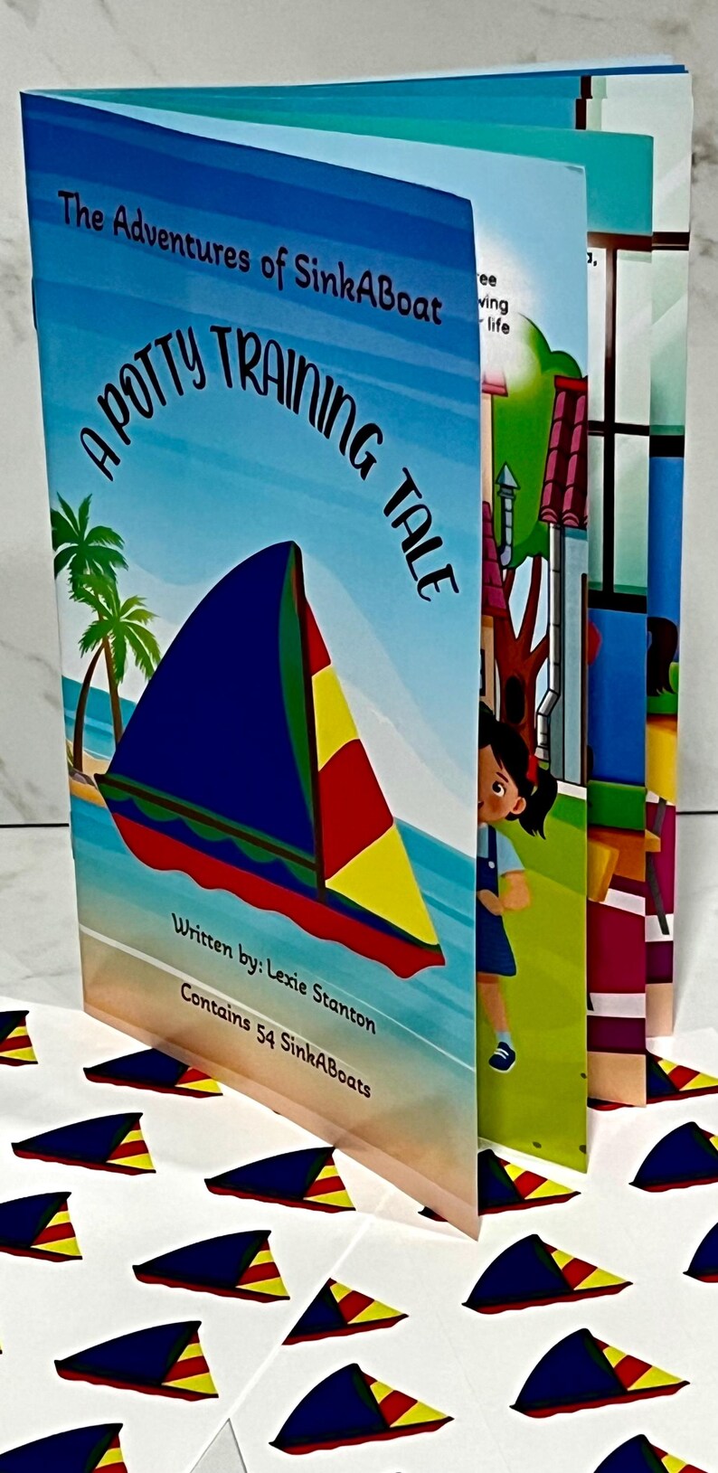 K&ouml;nnte beinhalten: Ein Kinderbuch mit dem Titel "The Adventures of SinkABoat: A Potty Training Tale". Das Cover zeigt ein Segelboot mit blauem Segel, roten und gelben Akzenten und Palmen. Das Buch enth&auml;lt 54 SinkABoats.