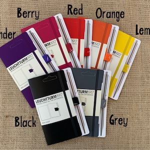 May include: A set of ten notebooks with matching pens in various colors, including lavender, berry, red, orange, lemon, black, and grey. Each notebook features the text "LEUCHTTURM1917" and "DETAILS MAKE ALL THE DIFFERENCE".