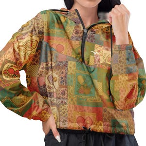 May include: A patchwork-style jacket with a hood and a half-zip closure. The jacket features a mix of colors including green, red, and gold. The model is wearing black pants. The jacket has a drawstring at the waist.