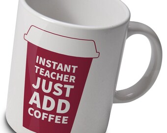 May include: White ceramic coffee mug with a red graphic of a coffee cup and the text "INSTANT TEACHER JUST ADD COFFEE". The mug has a curved handle and is designed for hot beverages.