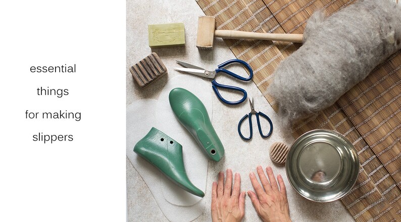May include: A flat lay of supplies for making felt slippers, including two green shoe forms, a ball of gray wool, two pairs of scissors, a wooden mallet, a bar of soap, a wooden scrubber, and a metal bowl.