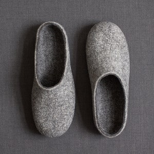 May include: A pair of gray felt slippers. The slippers are soft and comfortable, perfect for keeping your feet warm in the winter.