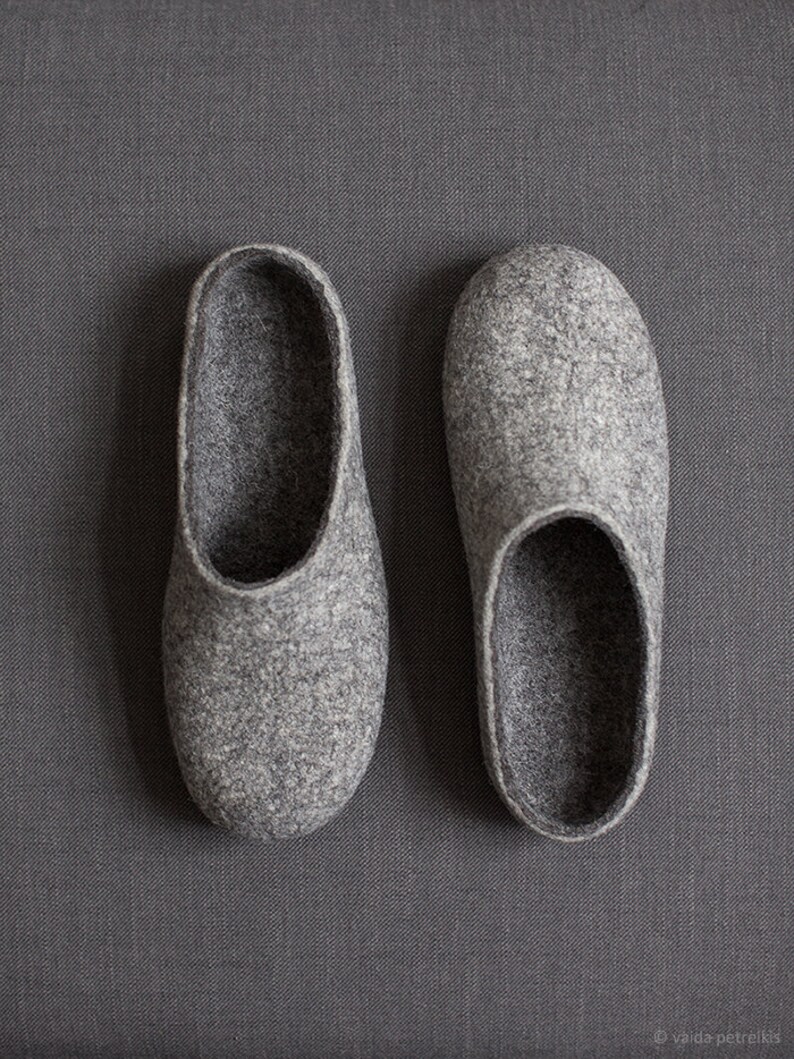 May include: A pair of gray felt slippers. The slippers are soft and comfortable, perfect for keeping your feet warm in the winter.