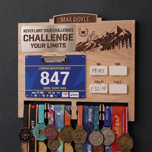 May include: A wooden race medal and bib display board featuring the name MAX DOYLE, a metal plate with the text NEVER LIMIT YOUR CHALLENGES CHALLENGE YOUR LIMITS, a blue London Marathon 2021 bib number 847, and white slots for race times.
