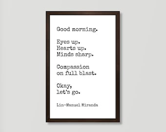 以下が含まれることがあります： リン=マニュエル・ミランダの引用文「Good morning. Eyes up. Hearts up. Minds sharp. Compassion on full blast. Okay, let's go.」が書かれた白黒のタイポグラフィー印刷を額装したもの