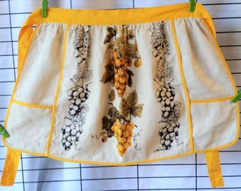 Luther Travis half apron, golden grapes on beige linen, yellow trim 26" wide X 16" long Fallani and Cohn NOS unused Excellent vintage condtn