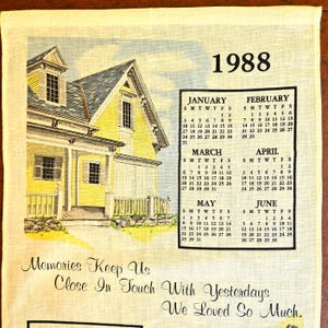 May include: A vintage calendar towel featuring a yellow house illustration with a blue sky background. The year 1988 is displayed at the top, with calendar months from January to June. Text reads "Memories Keep Us Close In Touch With Yesterdays We Loved So Much."