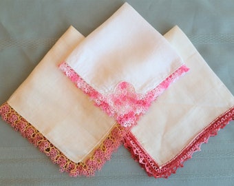 Three linen hankies, two trimmed with tatting, one with crochet in different shades of pink, from 10.5" to 12.5" sq. Excellent vintage cond