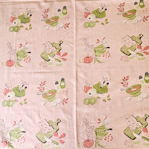May include: Pink kitchen towel with a repeating pattern of green and white kitchen utensils, vegetables, and spices. The design includes bowls, cutting boards, tomatoes, and lemons. The towel has a vintage aesthetic.