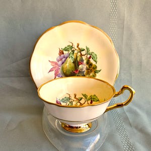 Woodlands Fruits teacup and saucer with pears, grapes, & cherries on pale yellow background, gold trim, Bone China England, Exc vintage cond
