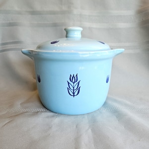 Peut inclure: Un plat à casserole en céramique bleu clair avec un couvercle. Le plat présente des motifs de tulipes bleu foncé et de petites poignées. Le couvercle a un petit bouton et des accents bleu foncé. Un ajout charmant à toute cuisine.