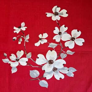 May include: A red fabric with a floral pattern. The design features white dogwood flowers with brown centers and gray leaves and stems. The flowers are arranged in a flowing, naturalistic style.
