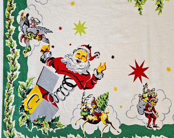 Santa Claus Jack-in-the-Box Tablecloth 50" x 44" vivid colors, elves, reindeer, toys, on heavy white cotton Very Gd to Exc vintage cond